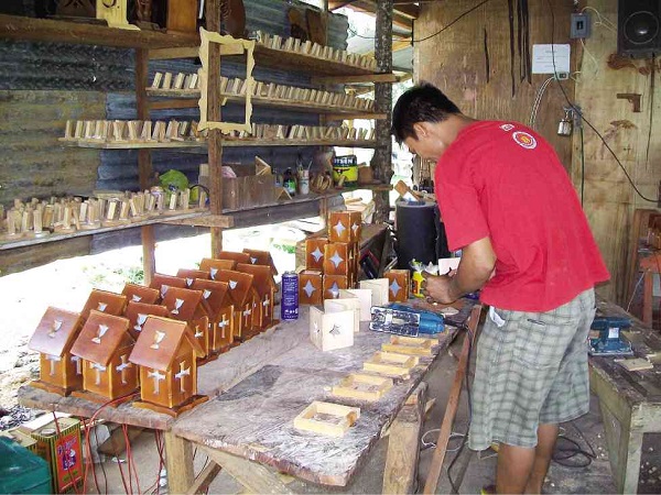 A man crafting wooden lampshades